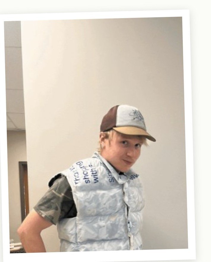 Upcycled puffer vest made from fused grocery bags, styled with a trucker cap