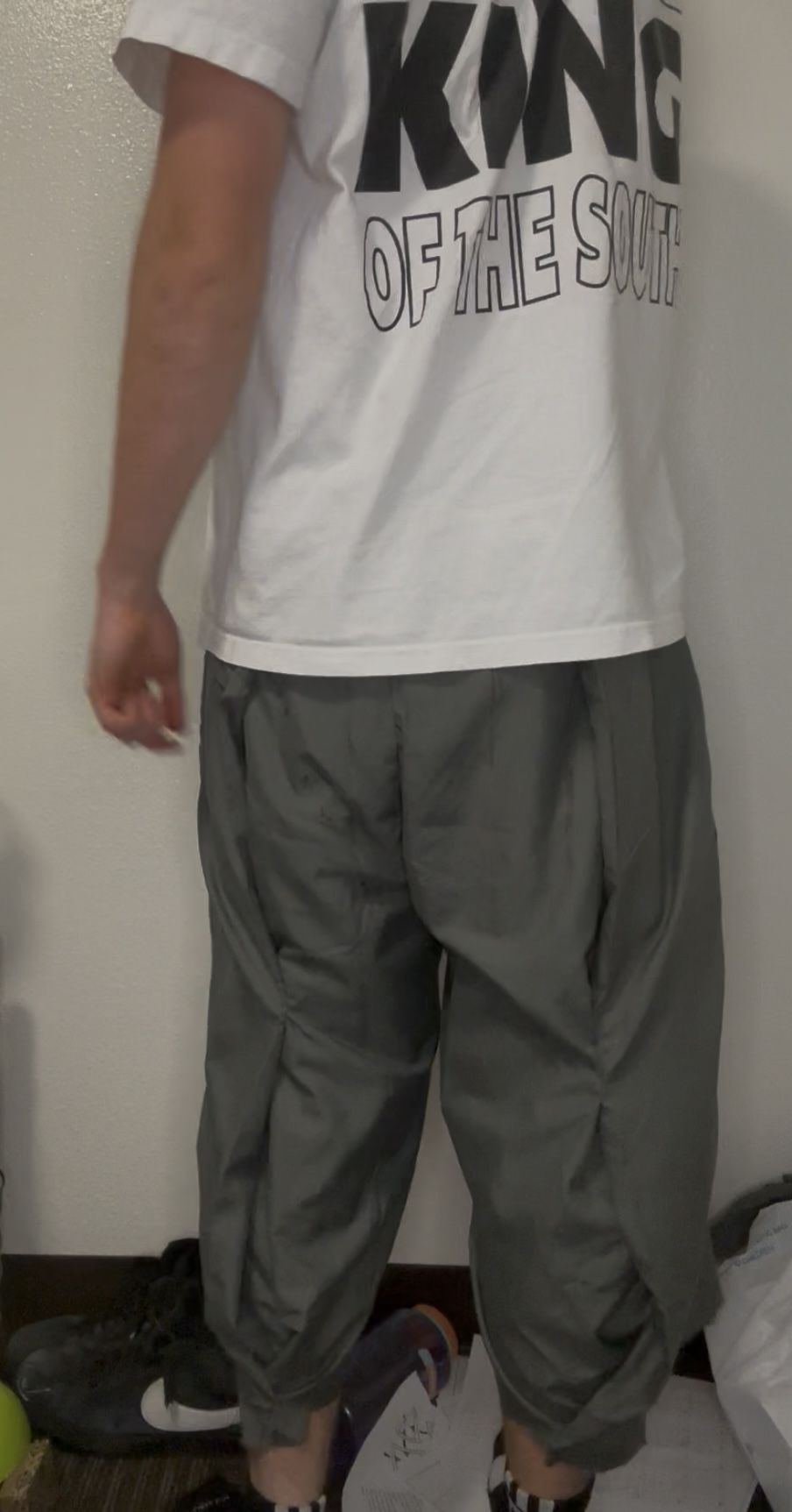 Balloon pleat trouser fit sample, back view, gathered cuff worn over a boot